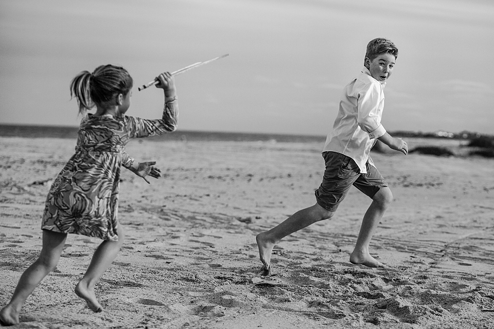 girl chasing boy on beach