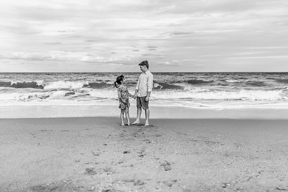 siblings by the water holding hands