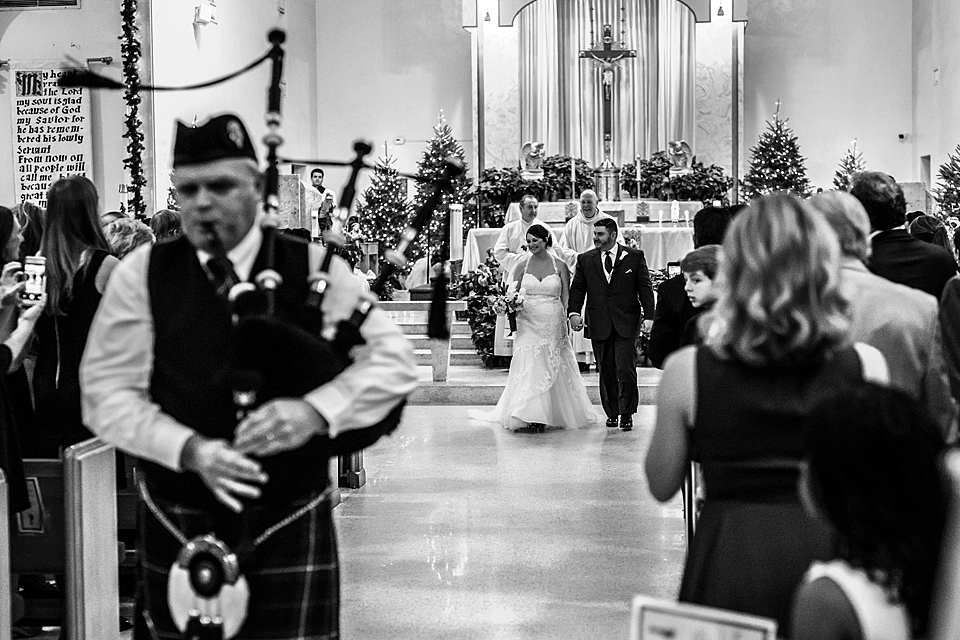 The bride and groom being exited out by a bag piper at St. Helens Church