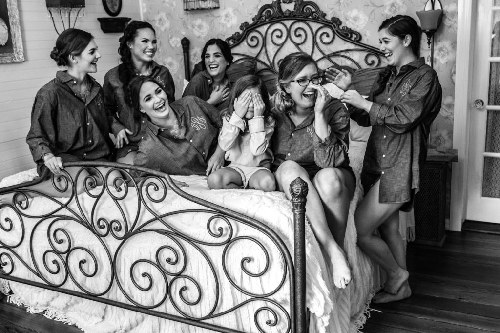 bridemaids laughing on the bed before wedding
