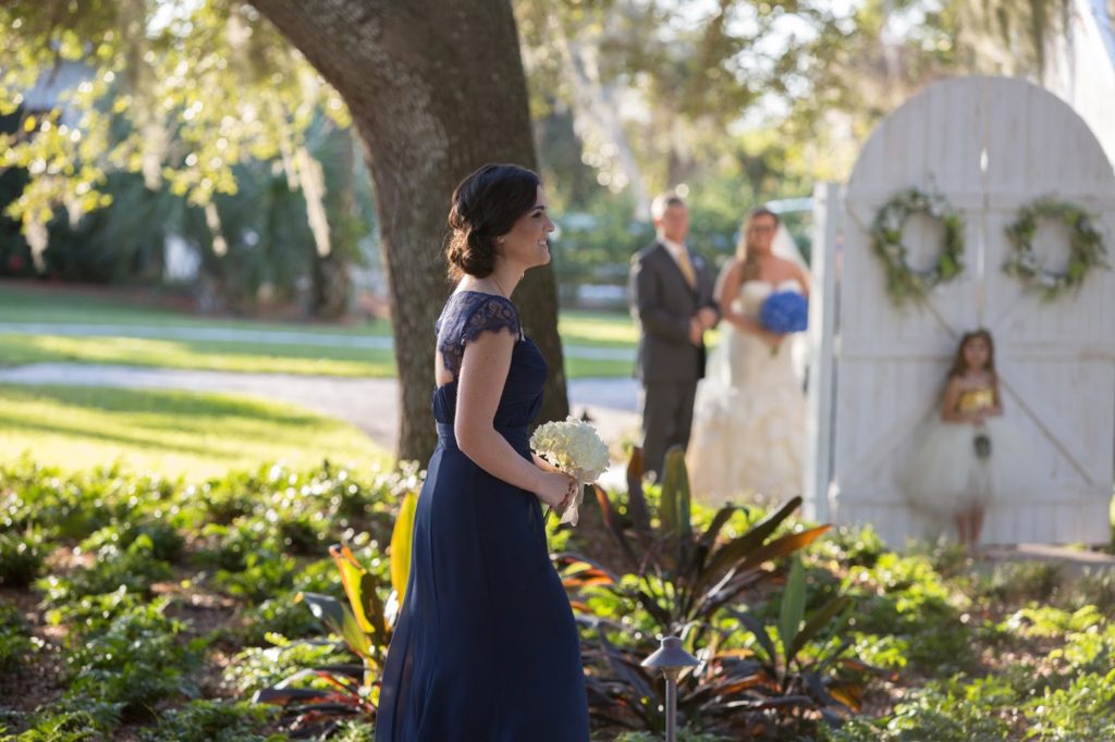bridesmaid walking with the bride and her dad looking at her