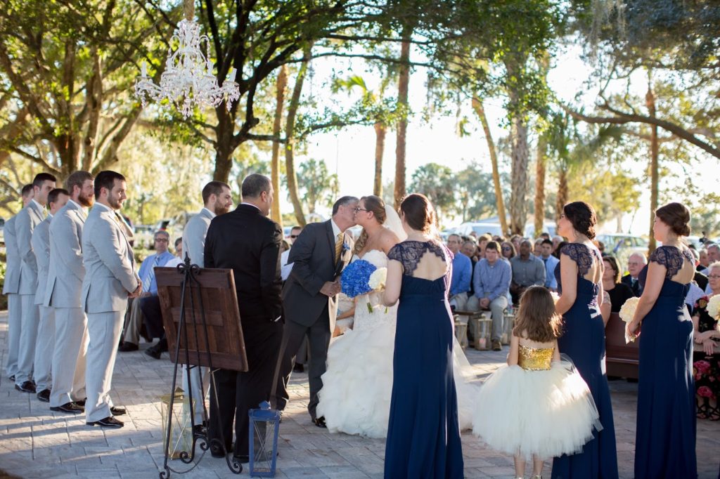 father kissing his daughter on the cheek during the wedding ceremony