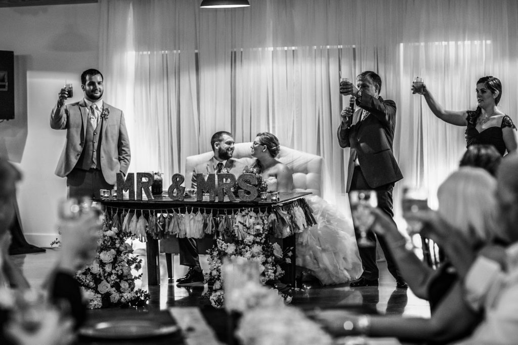 groom smiling at his wife during the toasts
