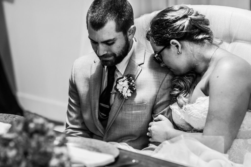 holding onto her husband during prayer before dinner