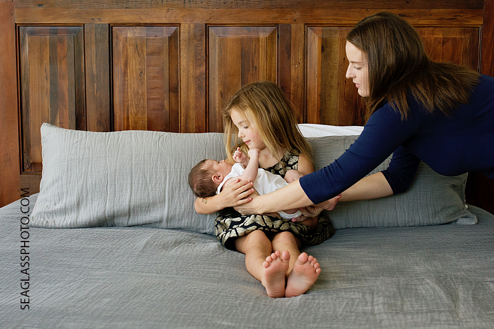 mom handing baby to girl Newborn Photos in Vero Beach Florida Lifestyle