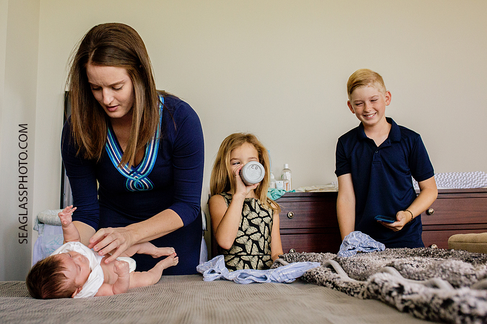 siblings playing while mom changes baby