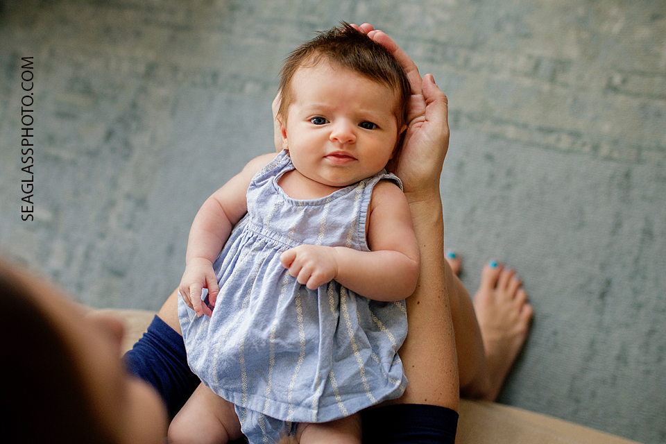 baby girl with eyes open starring at mom Newborn Photos in Vero Beach Florida Lifestyle