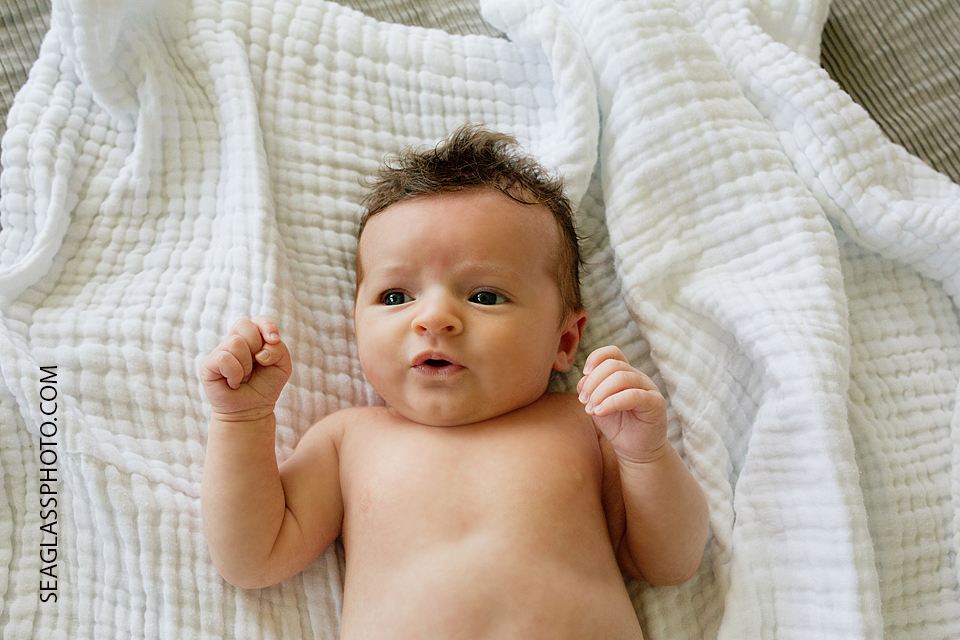baby girl laying on a white blanket Newborn Photos in Vero Beach Florida Lifestyle