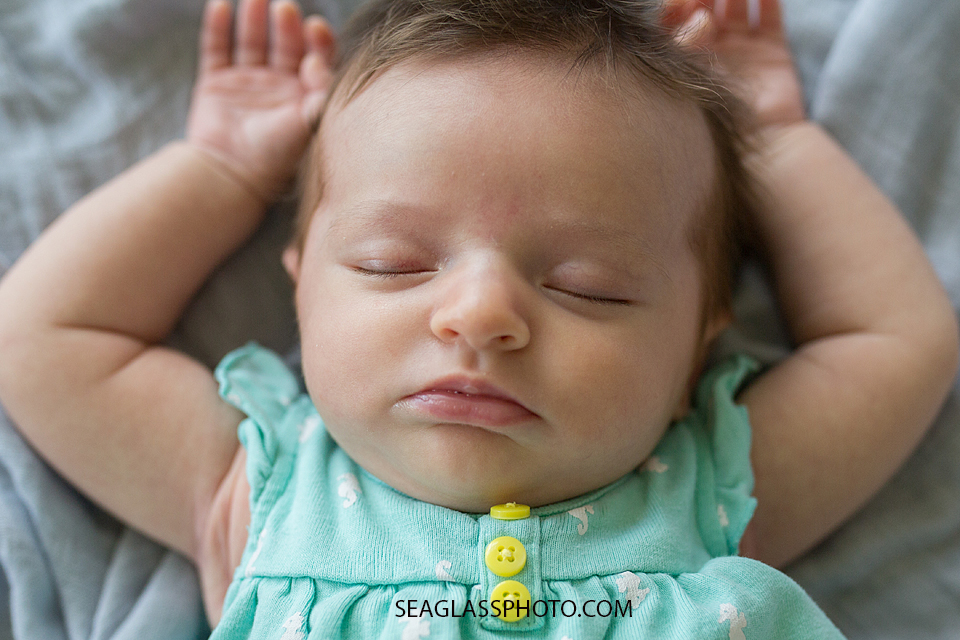 newborn girl sleeping with arms up 