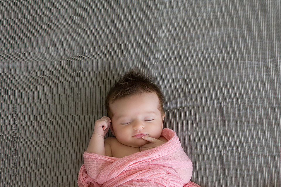 newborn baby girl swaddled in pink