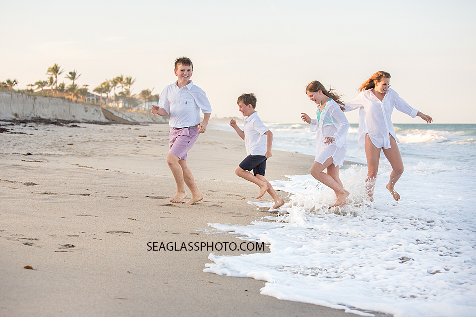 siblings running on the beach vero beach fl