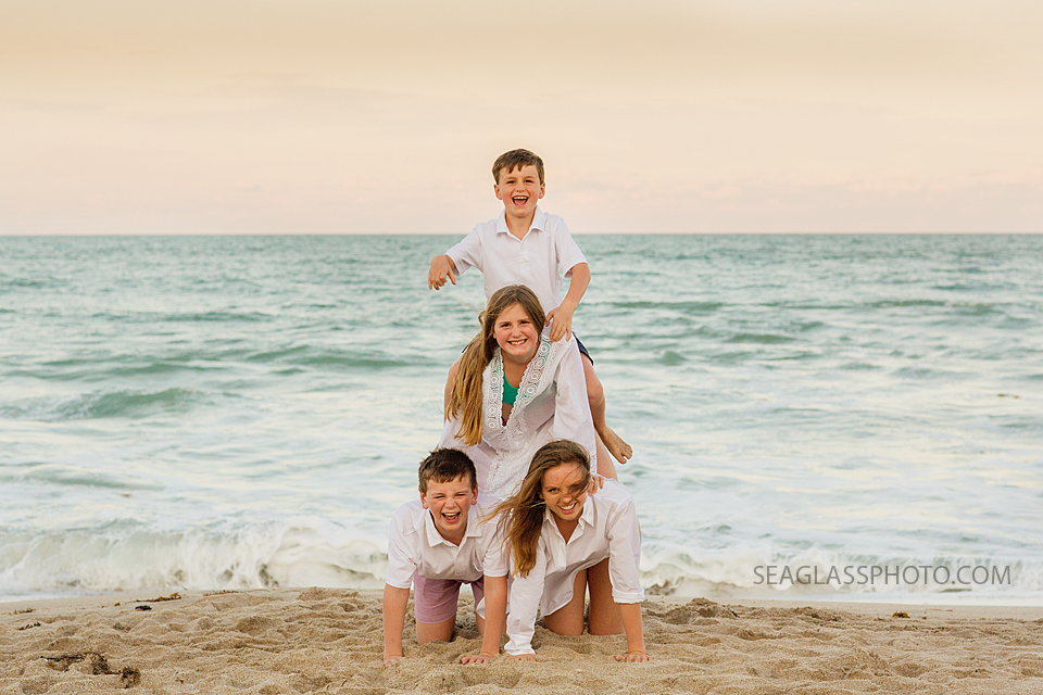 siblings making a human pyramid on the beach Windsor Vero Beach Flordida Family Photography