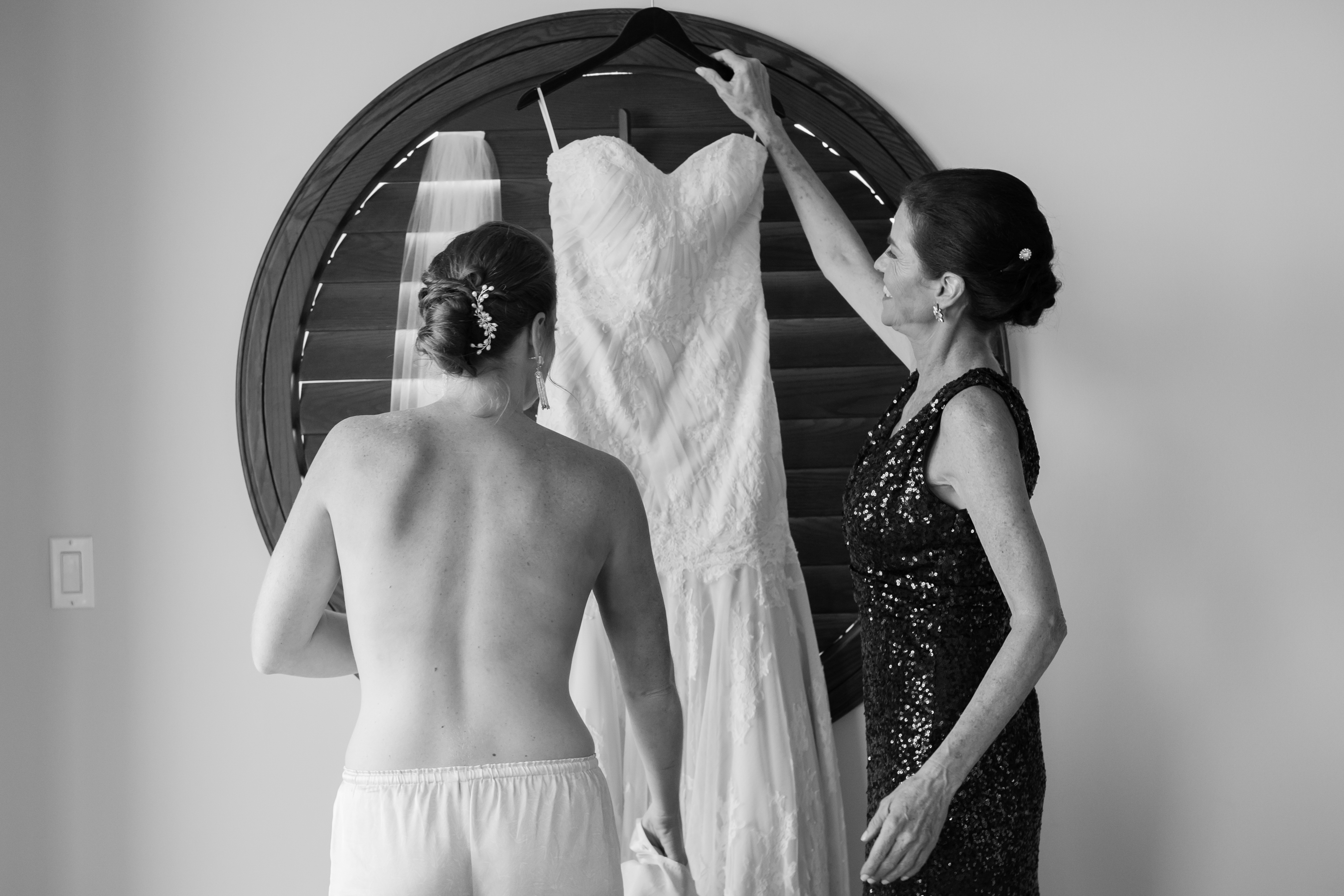 black and white photo of bride getting into her gown at costa d'este