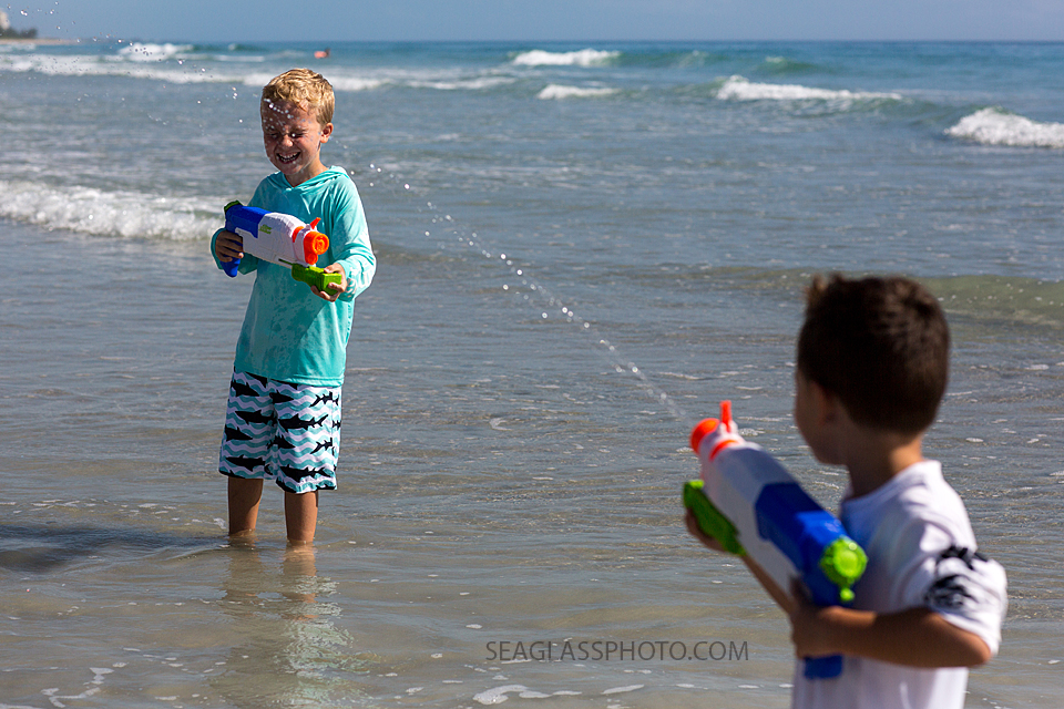 brothers playing with water guns on the beach in Vero Beach Fl
