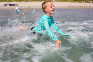 brother splashing in the ocean in Vero Beach Florida