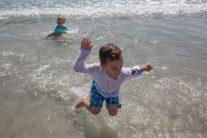 Brothers jumping up and down in the water in Vero Beach Florida