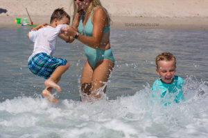 mom playing in the waves with her two sons in Vero Beach Florida