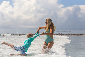 Mom swinging her son around in the ocean in Vero Beach Florida