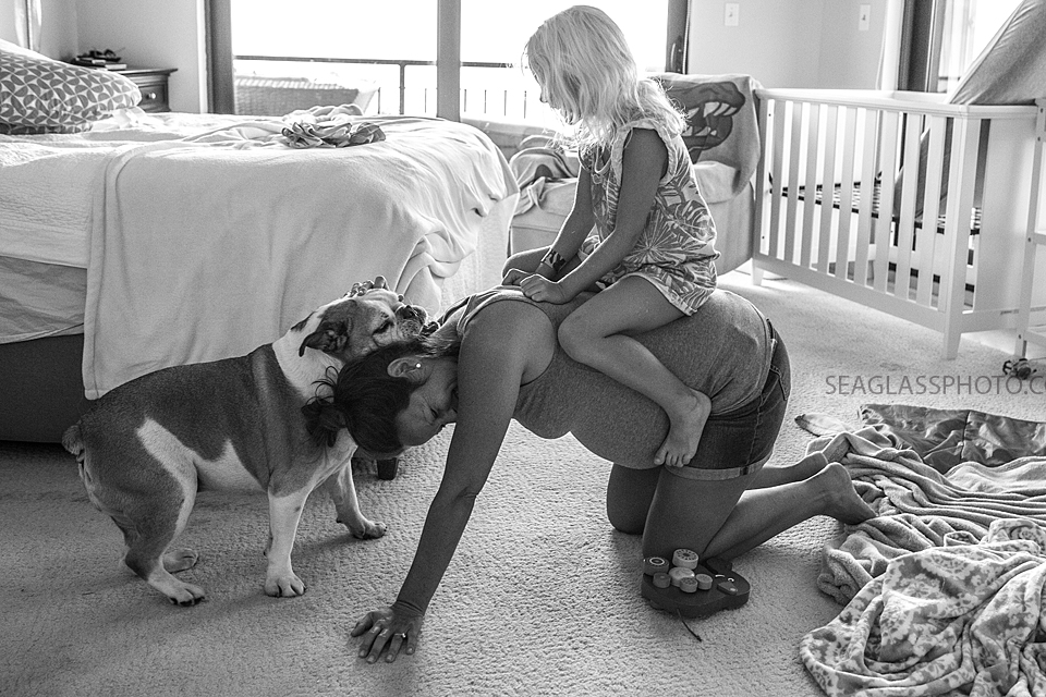 black and white of pregnant mom playing with daughter