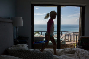 girl walking on bed with an ocean view