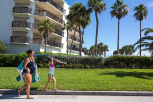 pregnancy photo of mom walking to the beach with her daughter