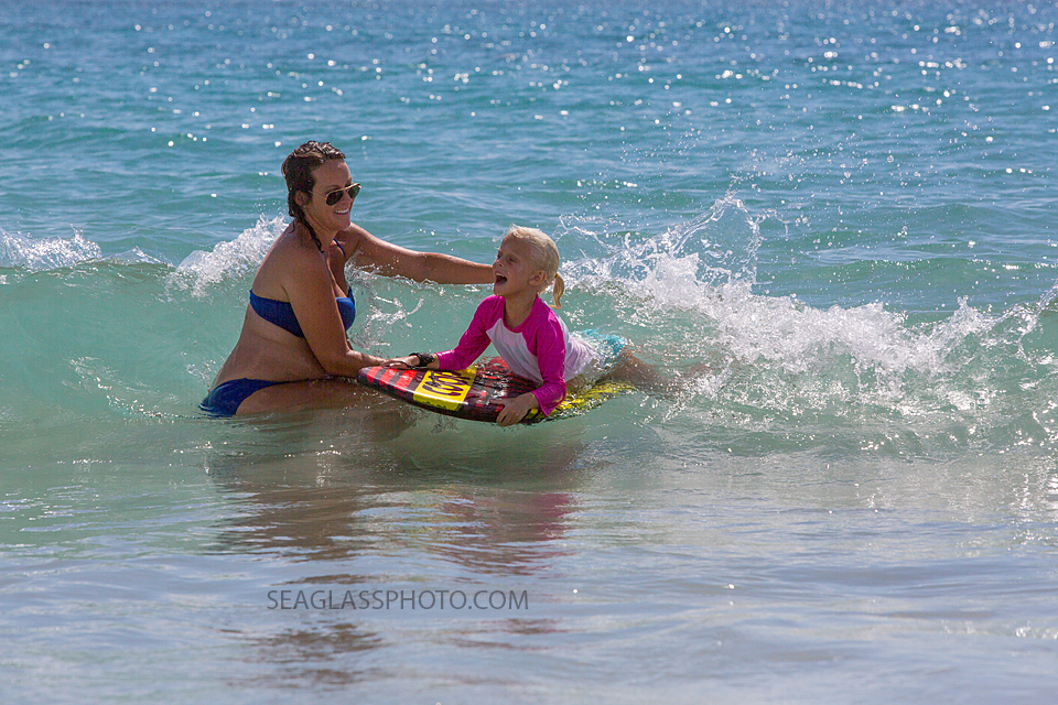 pregnant mom and daughter playing in the waves in Vero Beach Florida