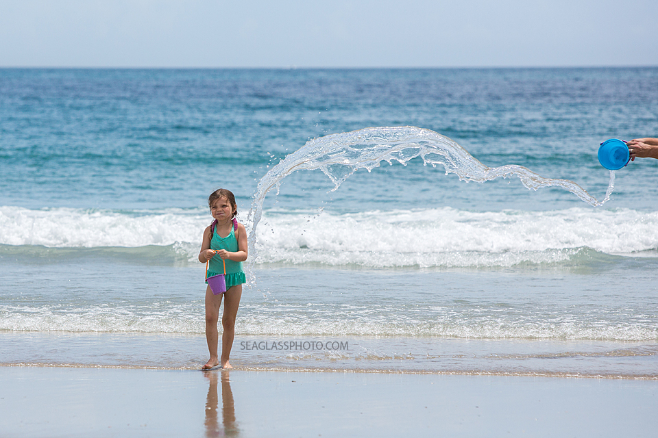 Toddler girl being splashed by water at the beach in Vero Beach Florida 