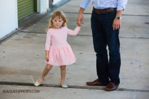 Little girl wearing pink tutu dress holding her father's hand Family of four at Walking Tree Brewery in Vero Beach Florida