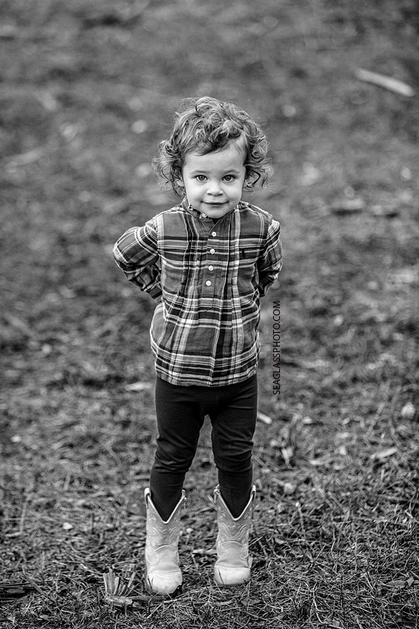 Black and White photo of toddler girl wearing plaid shirt and boots