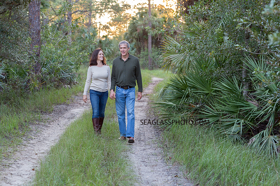 Couple walking on a path in the woods on a sun shining day in Vero Beach Florida
