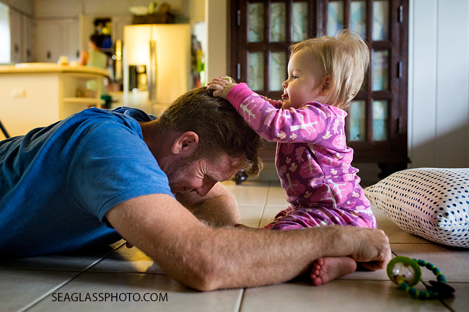 baby girl playing with her fathers hair while wearing pink pajamas family documentary vero beach florida