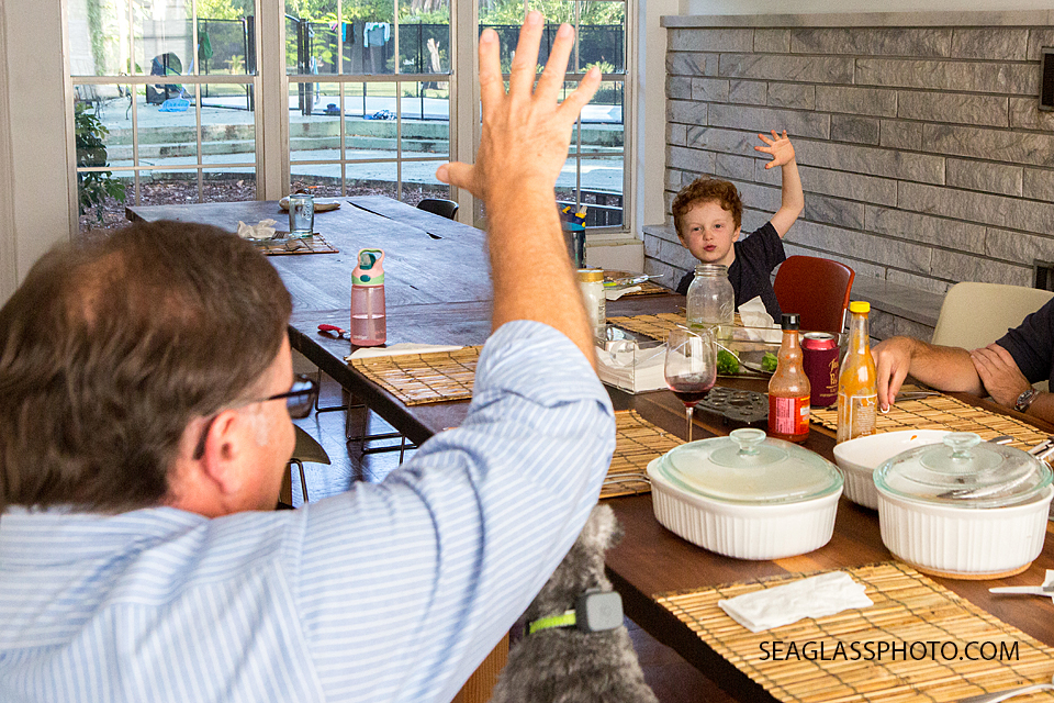 Grandfather and little boy fist bumping across the dining room table family documentary vero beach florida
