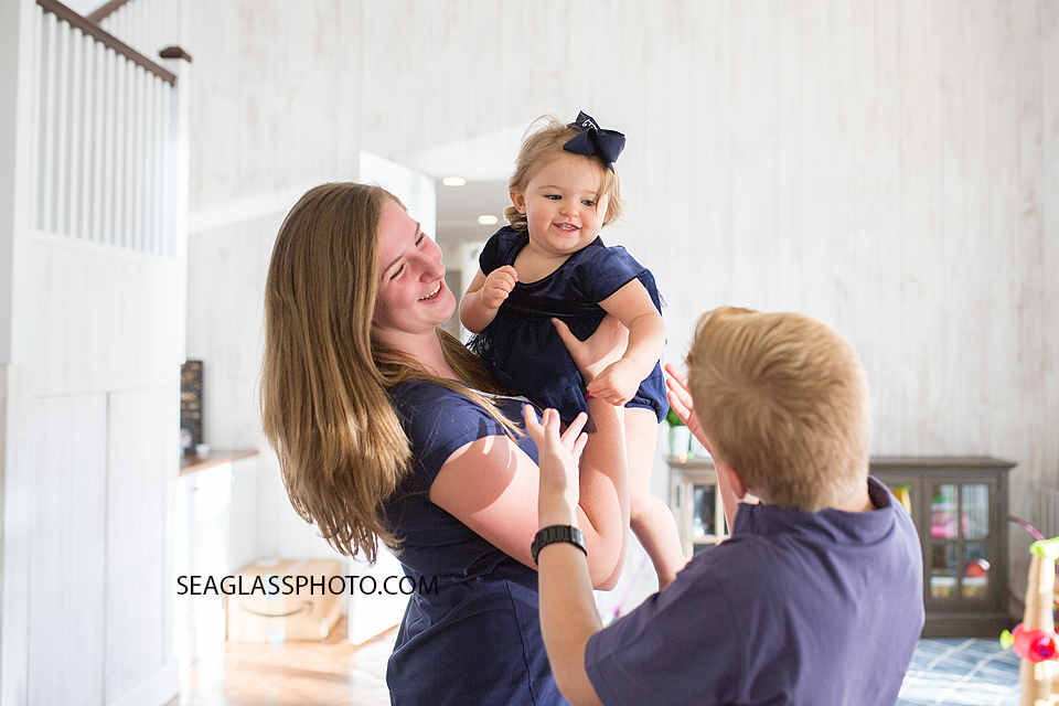 Siblings playing together wearing navy in a white room in Vero Beach Florida family photography