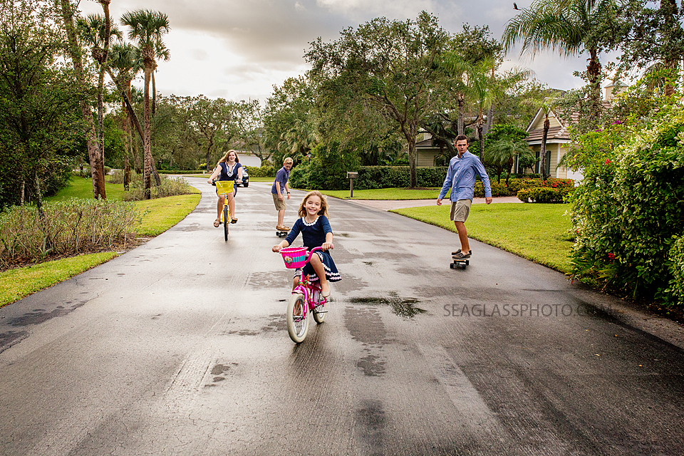 siblings riding bikes and skateboards after the rain on Vero Beach Florida family photography