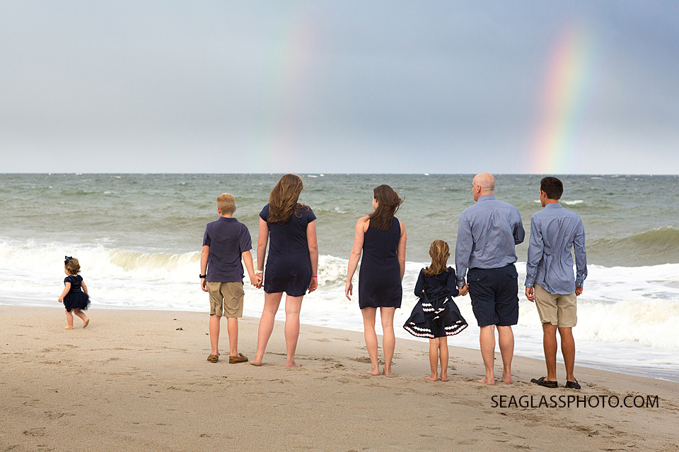 family wearing navy standing on the beach looking at a rainbow in Vero Beach Florida family photography