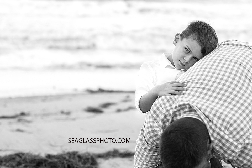 black and white photo of young boy holding onto his dad Vero Beach Florida family Photography