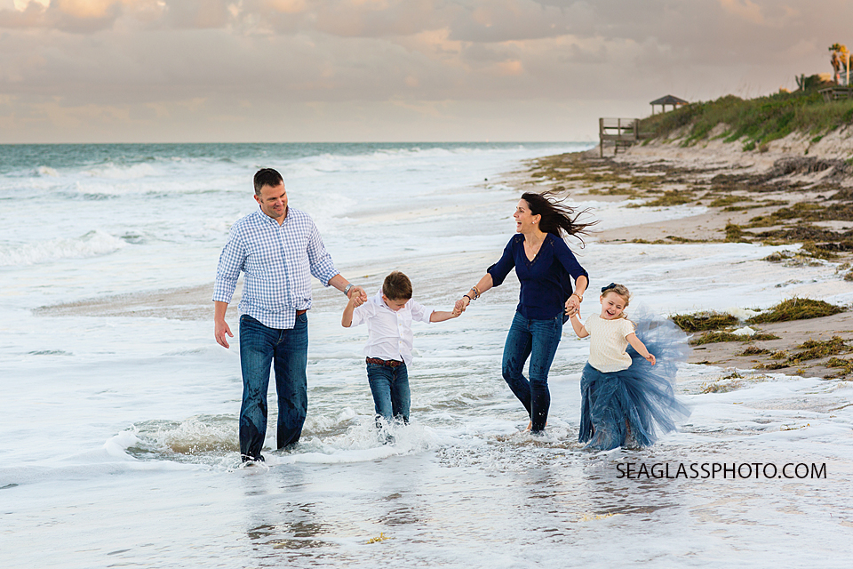 family wearing navy and white on the beach at sunset walking hand in hand Vero Beach Florida family Photography