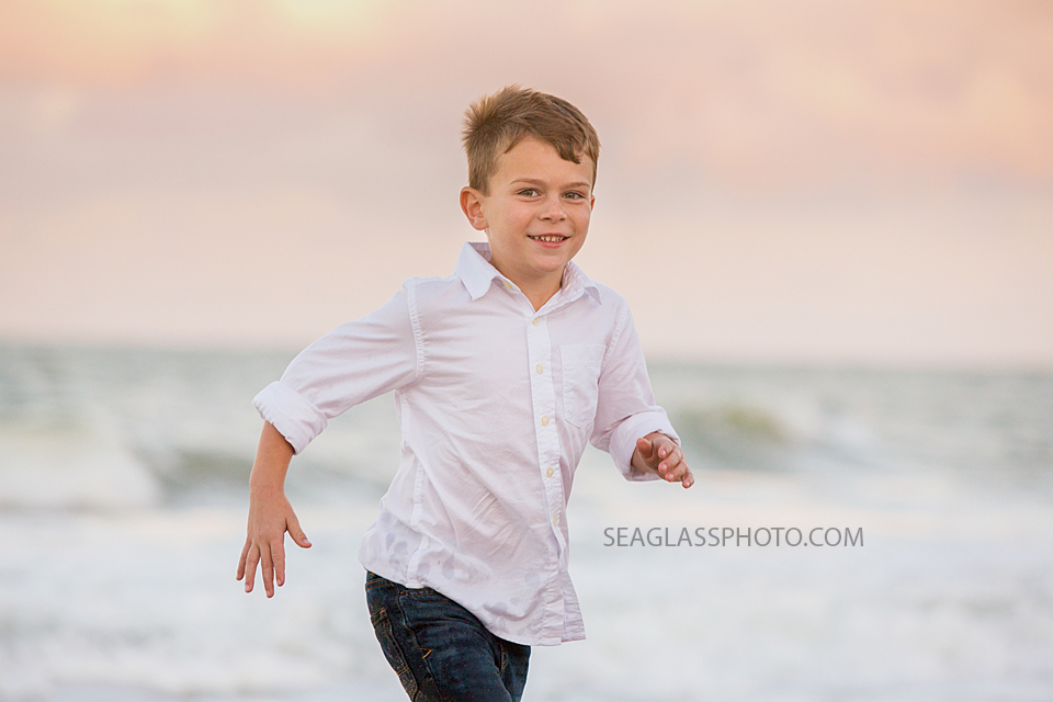 Boy wearing white shirt running on the beach at sunset Vero Beach Florida family Photography