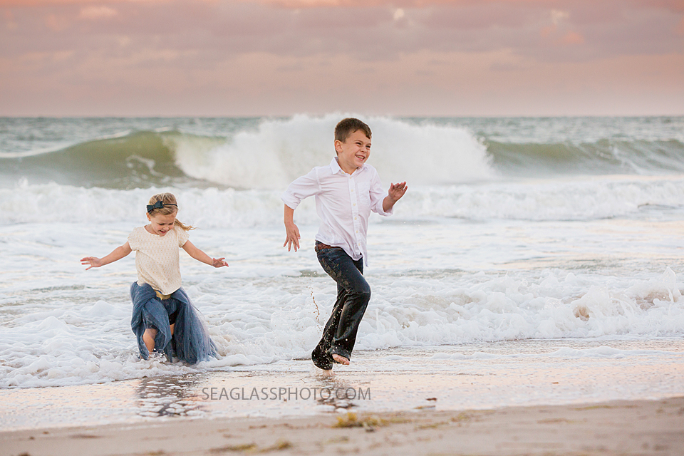 sister and brother running out of the waves at sunset Vero Beach Florida family Photography