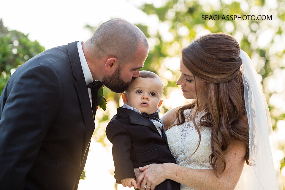 bride and groom holding and kissing baby Vero Beach Florida Wedding