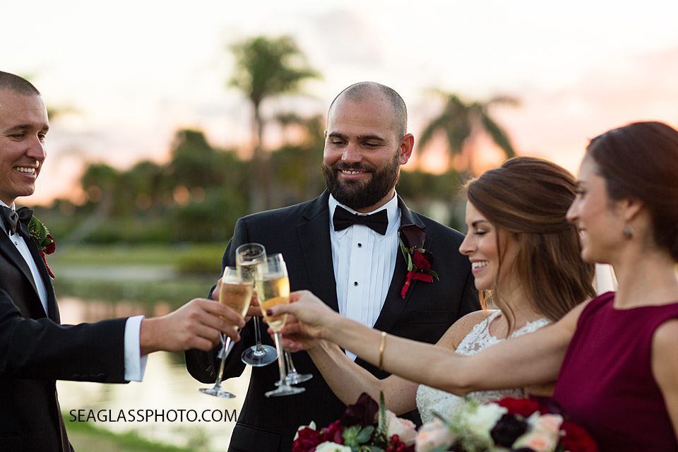 bridal party cheers to the sunset at Grand Harbor Vero Beach Florida Wedding