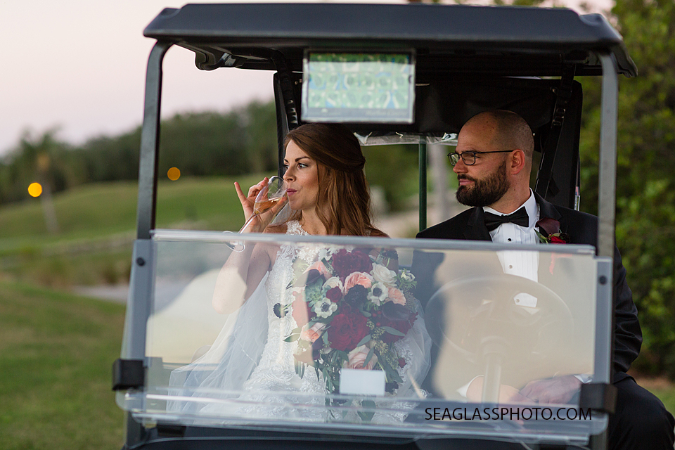 bride and groom sip champagne in a golf cart at Grand Harbor Vero Beach Florida Wedding