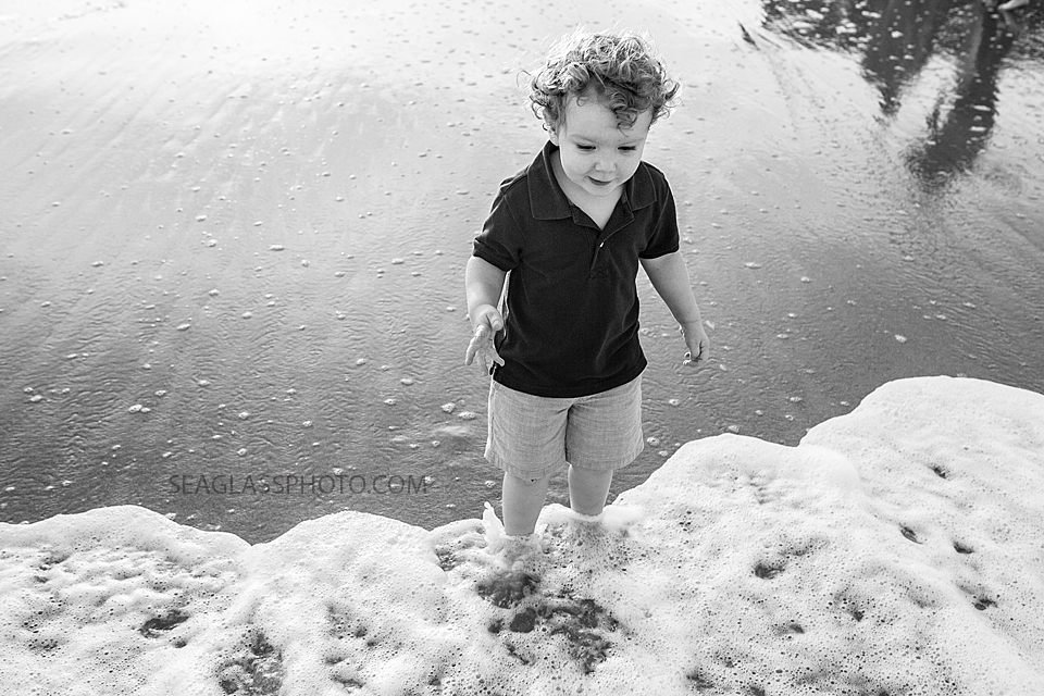 black and white photo of boy standing on the shoreline in Vero Beach Florida Family Photographer