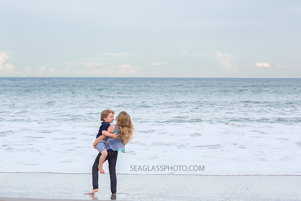 siblings standing on the shoreline n Vero Beach Florida Family Photographer