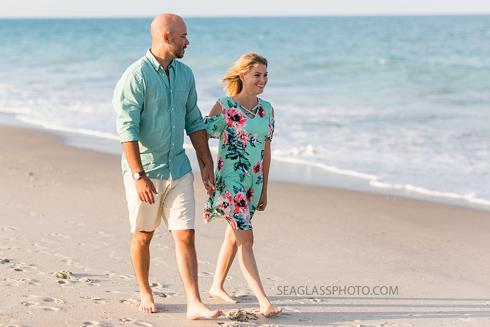 Couple walks on the beach during family photos in Vero Beach Florida
