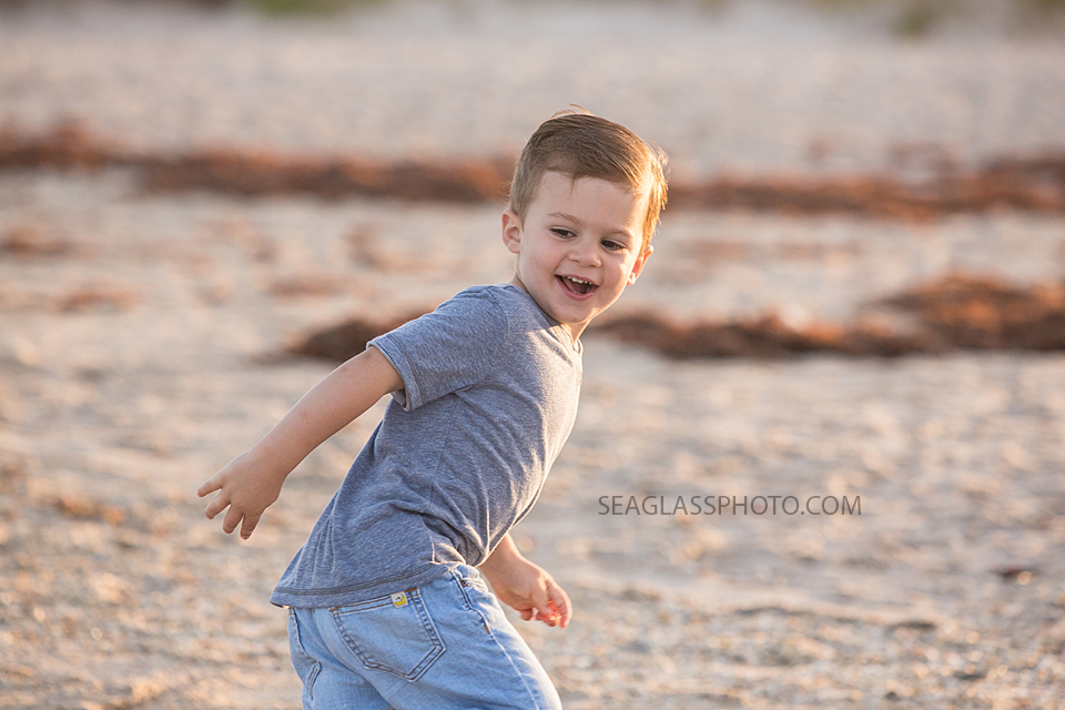 Close up of young boy running on the beach during maternity photos in Vero Beach Florida