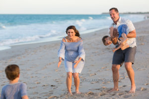Family playing around on the beach during maternity photos in Vero Beach Florida