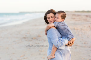 Pregnant mom holding son on the beach wearing blue for maternity photos in Vero Beach Florida