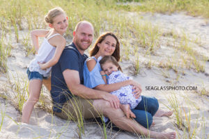 family posing on the beach near the dunes for family photo shoot in Vero beach florida
