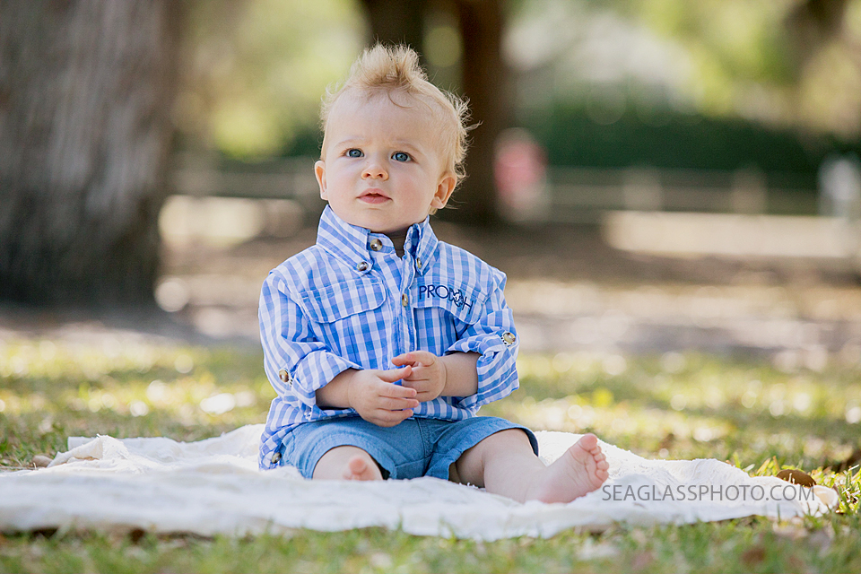 Close up of little boy sitting on a blanket at Riverside park during family photo shoot in Vero Beach Florida